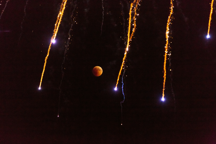 Red moon with firework